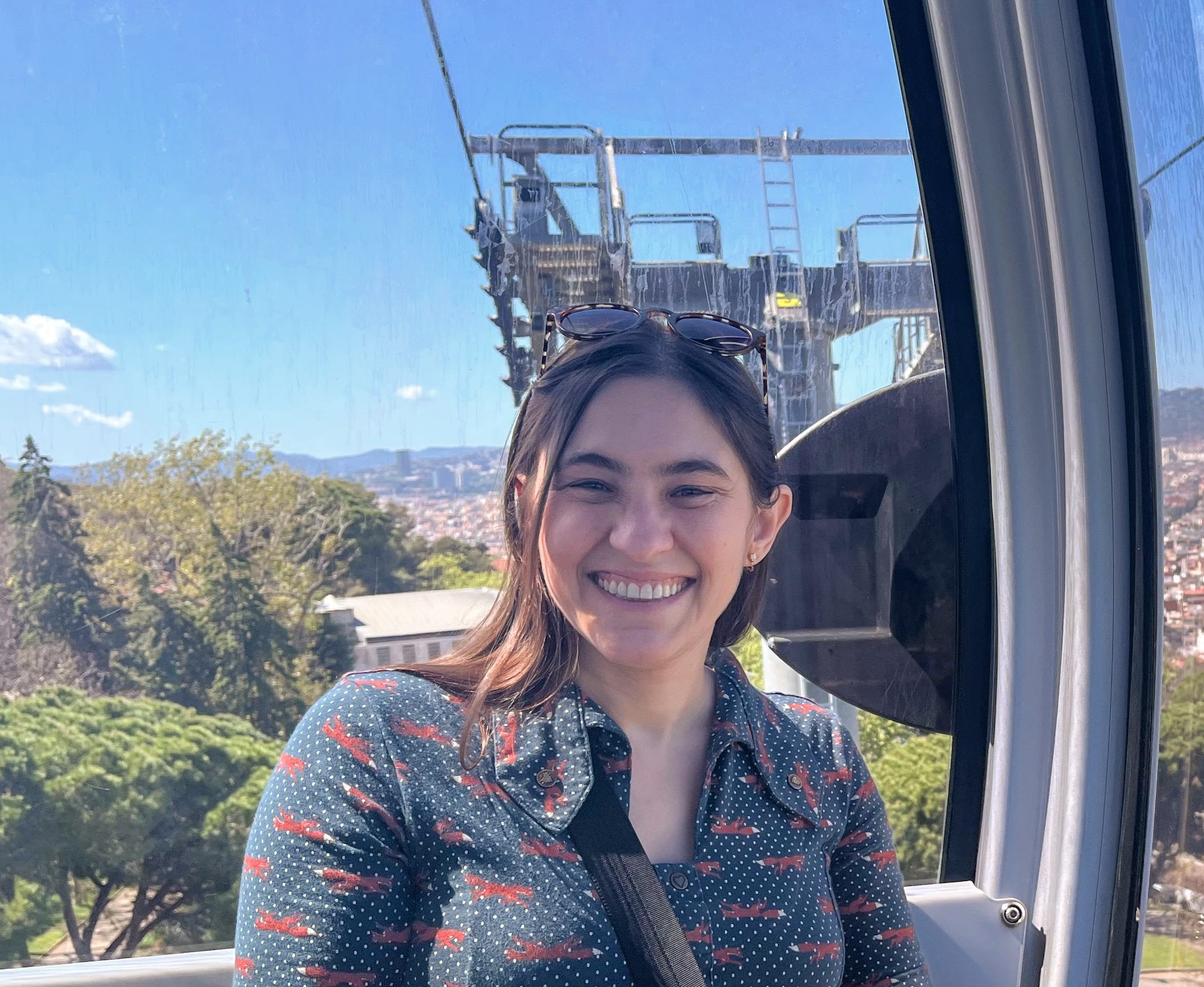 Anne, a white woman with shoulder length brown hair, smiling in front of a scenic backdrop